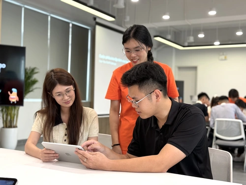 Hai nhân sự được thực hành về code với ngôn ngữ Swift tại trung tâm đào tạo do Apple và Đại học Bách Khoa Hà Nội cùng thành lập, sáng 27/8. Ảnh: Tuấn Anh.