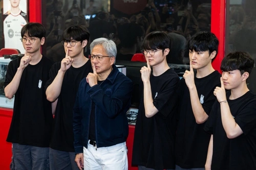 CEO Nvidia cùng Faker và các tuyển thủ T1 tạo dáng "Suỵt" - biểu tượng ăn mừng chiến thắng kinh điển của Faker trong các giải đấu lớn trước ống kính truyền thông. Chuyến thăm này vừa thể hiện sự tôn trọng của Nvidia đối với hệ sinh thái gaming Hàn Quốc, vừa là bước đi truyền thông đỉnh cao của hãng. Ảnh: