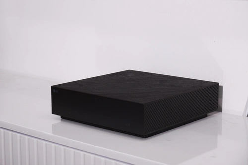 Hộp Zero Connect của W6 năm nay được làm mỏng hơn hẳn, nhưng lại tăng về chiều ngang so với đời M5. Thiết kế như một chiếc máy chơi game, chất liệu nhám khiến cho phụ kiện này trông bắt mắt hơn hẳn. Đáng chú ý, LG cũng bỏ đi phần điều khiển hướng kết nối, giúp vẻ ngoài liền lạc hơn.